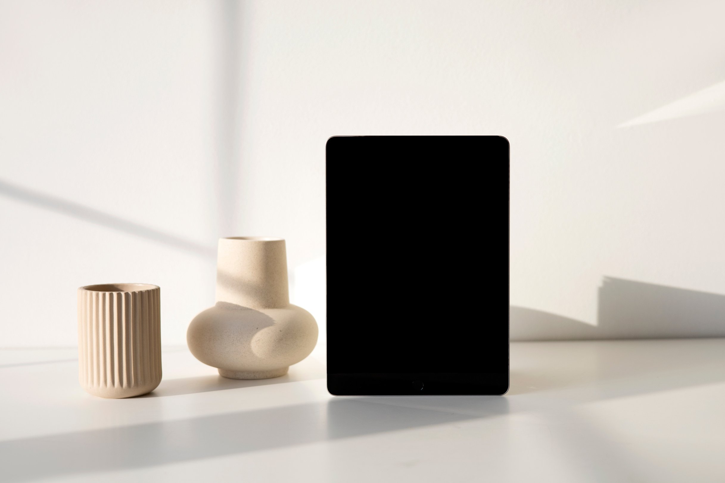 Black Ipad beside Vases